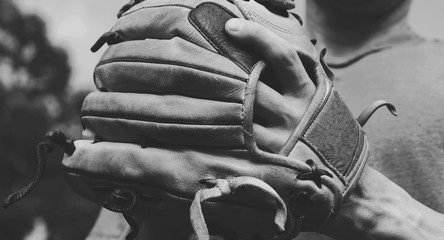 Vintage style sports concept shows hand in baseball glove close up.