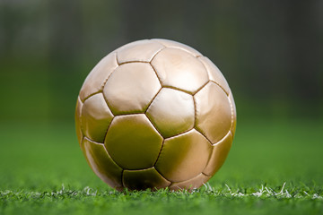 Fototapeta premium Closeup soccer golden ball on green grass