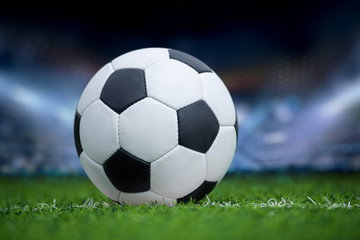 Naklejka na ściany i meble Closeup soccer ball in green grass on stadium