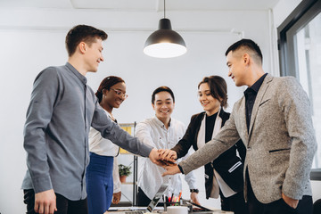 Multiracial euphoric business team people give high five at office table, happy excited diverse...