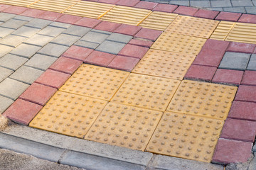 Ramp for wheelchair and other wheeled pedestrian transport made from tiles of various color....