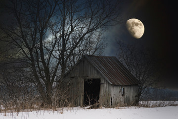 A isolated lonely shack sits in a field lit by the moonlight overhead. Rural farmland near Tyendinaga Mohawk Territory. © Jason
