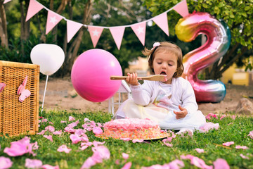 Little girl celebrate Happy Birthday Party with rose decor in the beautiful garden