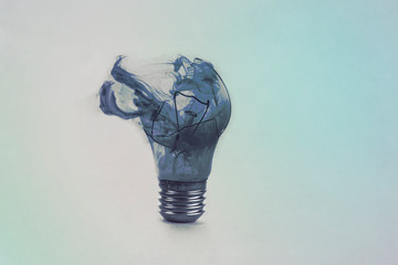 One broken light bulb on a blue background with smoke. Overdue idea concept.