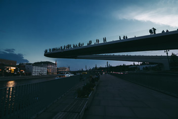 floating bridge with people above Moscow river in the park Zaryadye near Red Square. Bottom view of the Hovering modern bridge in Moscow. Soaring bridge is modern architectural landmark