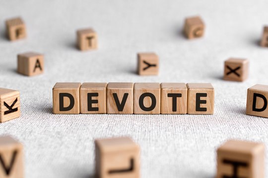 Devote - words from wooden blocks with letters, to give all of something devote concept, white background