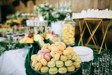 Colorful macaroons  at dessert table at wedding party.  Sweet food