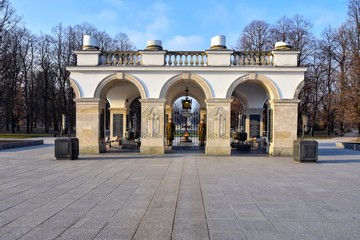 Obraz premium Warsaw, Poland - January 2020. Elegant white colonnade with eternal flame on the tomb of the unknown soldier. Monument in honor of Second World War. View from the Pilsudski Square. 