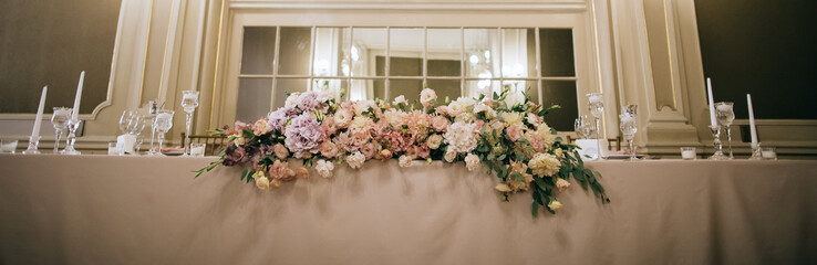  Wedding decor. Fresh bouquets of flowers on the table of the bride and groom at the restaurant