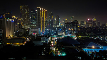 Naklejka premium Modern buildings of Jakarta with lights at night on background, view from Kuningan Jakarta, Indonesia