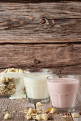 Two glasses of healthy strawberry and classic yogurt with oats on wooden table. healthy breakfast. close up with copy space. homemade fresh yogurts with cereals , two glasses of dairy product.