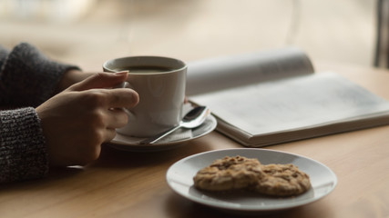 Cup of coffee and cookies on wooden table.
