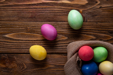 Easter composition. Colored eggs, burlap napkin on a wooden table.