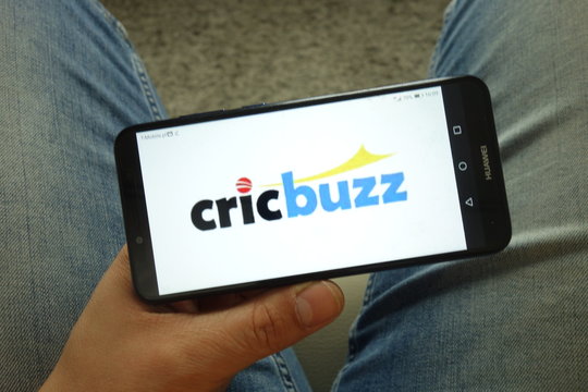 KONSKIE, POLAND - May 04, 2019: Man holding smartphone with CricBuzz website logo
