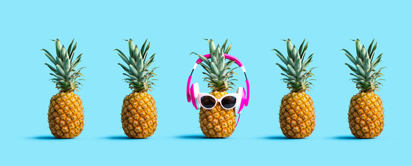 One out unique pineapple wearing headphones on a solid color background