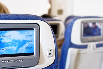 wide-body airplane cabin interior with seats and inflight entertainment system displays against...