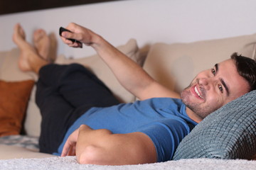 Relaxed man watching tv at home 
