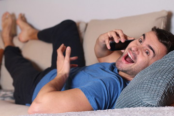 Man calling by phone from the sofa 