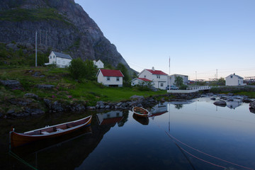 Norwegian houses on the lofoten with a mirror lake and small boats