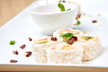 new trend in the Japanese cuisiune. Sweet sushi rolls in pancake with cream cheese, orange and kiwi, peach,