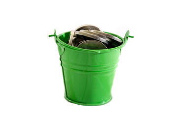 coins in a green bucket isolated on a white background. © Tania
