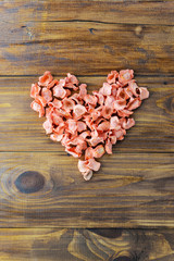 Heart carrot chips on a brown wooden table. Love for healthy eating concept.