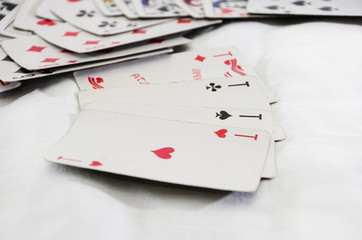 Four aces on a white background and scattered game cards.