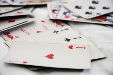 Four aces on a white background and scattered game cards.