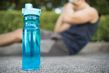 Man doing exercise next to bottle of water. 