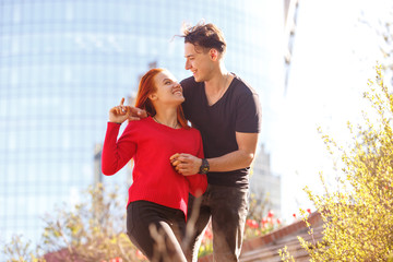 A young man with a girl hugging on the background of the stairs