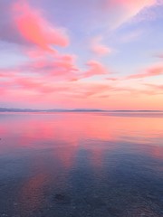 Zarter rosa Sonnenuntergang am Meer, rosa Blumenreflexion auf dem Meer