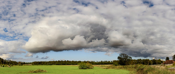 Storm cloud formation above green field
