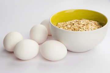 oatmeal and white chicken eggs on a white background