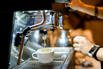 Coffee machine preparing an espresso for customers' breakfast in a European coffee shop.