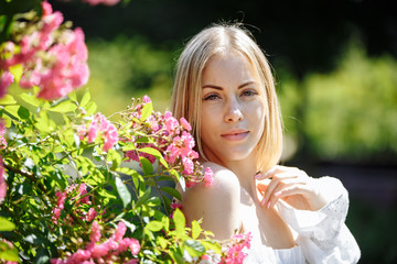 girl in a white dress in a garden of pink roses