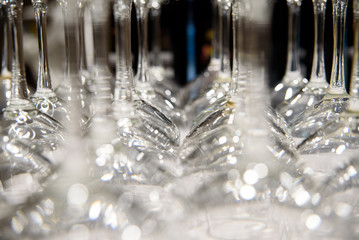 Detail of many clear and clean glass glasses arranged on the table of a bar to serve wine.