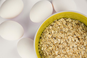 oatmeal and white chicken eggs on a white background