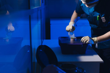 Specialist Embryologist Takes a capsule With Embryos from the Cryobank