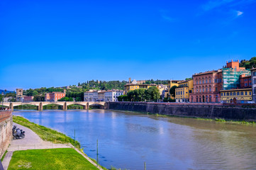 A daytime view along the Arno River in Florence, Italy.