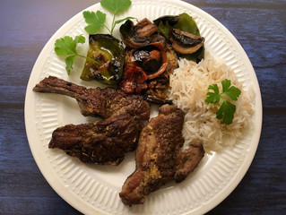 Grilled lamb chops and fresh vegetables with herbs and rice.