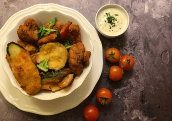 Breaded mushrooms and zucchini vegetables with herbs.