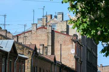 Fototapeta na wymiar Riga, May, 2008, Old brick houses with many TV antenas on the roof