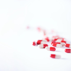 Macro of red capsules on white background. Copy space. Bunch of drugs, cold flu treatment. Coronavirus Covid-19.