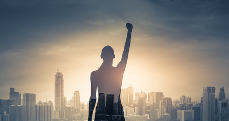 confident young woman with fist in the air facing the city. People power and strong young woman concept  - obrazy, fototapety, plakaty