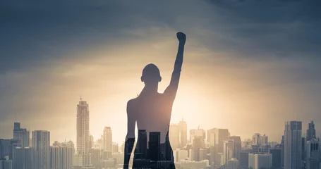 Foto op Canvas confident young woman with fist in the air facing the city. People power and strong young woman concept  © kieferpix