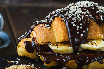 coffee and chocolate covered croissant sprinkled with chocolate