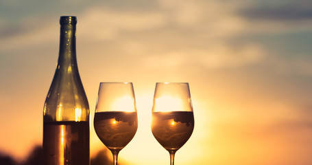 Wine glasses in a romantic sunset view setting. 
