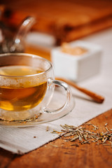 Cup of hot tea with rock sugar, dry tea leaves served in thermo glass tea cup