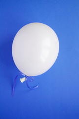 One white balloon on the blue  background. Location vertical. Top view. Copy space.