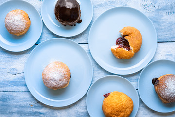 Homemade jelly donuts on blue plates. German berliner doughnuts